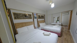 A hotel room with two beds, a bedside table, a mirror, and a wooden floor. - Senyor Garden Hotel (Istanbul)