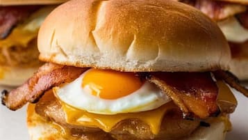 A breakfast sandwich with bacon, egg, and cheese on a bun.