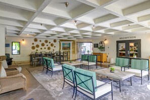 A hotel reception area with a check-in counter, seating arrangements, and a view of the outside. - The Lodge at Healdsburg, Tapestry Collection by Hilton (Healdsburg)