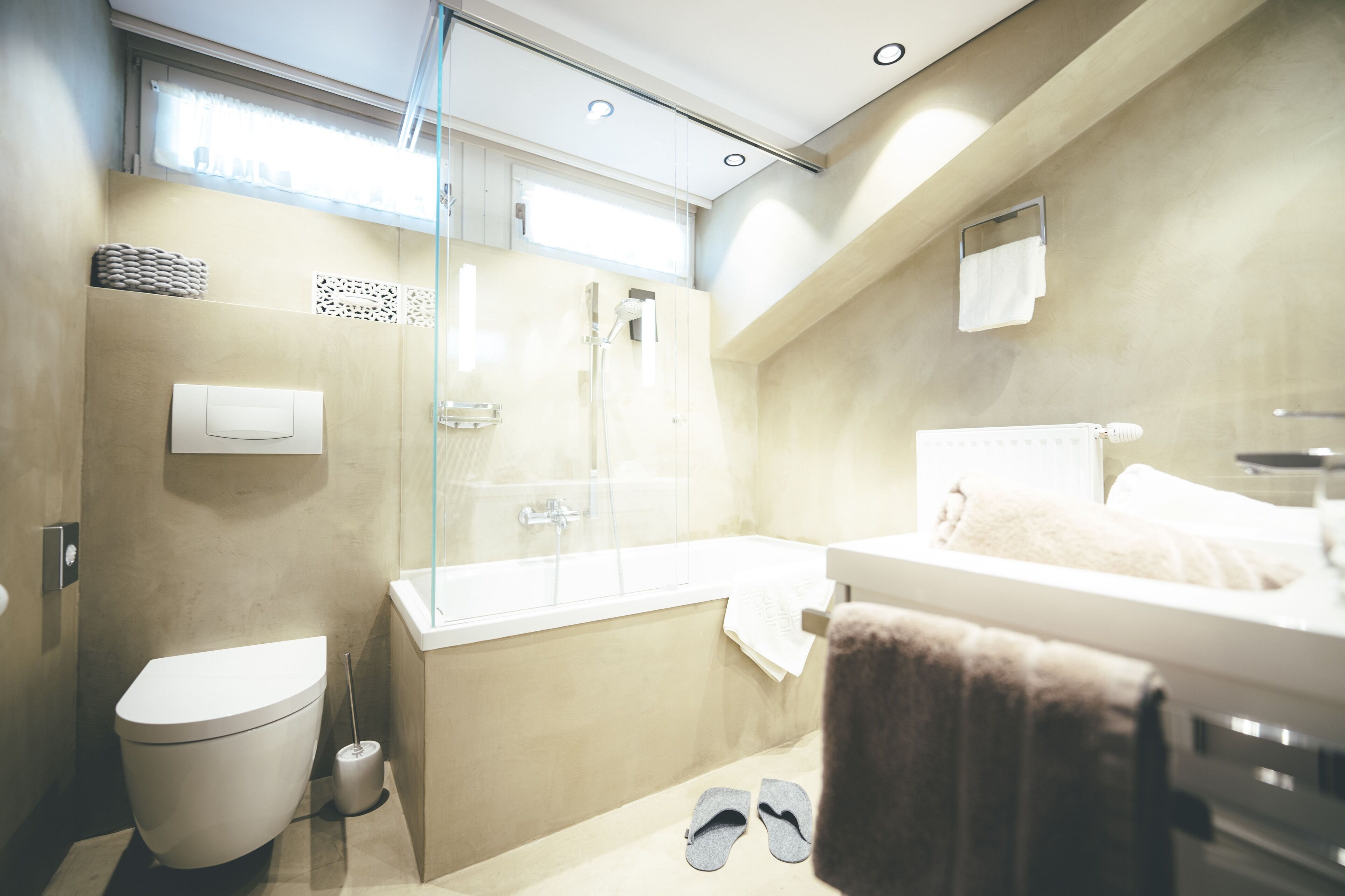 A modern bathroom with a toilet, shower, bathtub, and a towel rack.