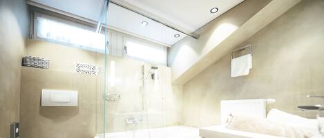 A modern bathroom with a toilet, shower, bathtub, and a towel rack.