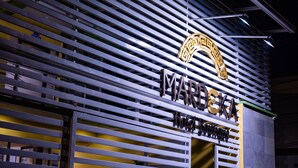 Facciata di un edificio con persiane orizzontali e un cartello che recita 'MARDESKA Hotel Boutique'.