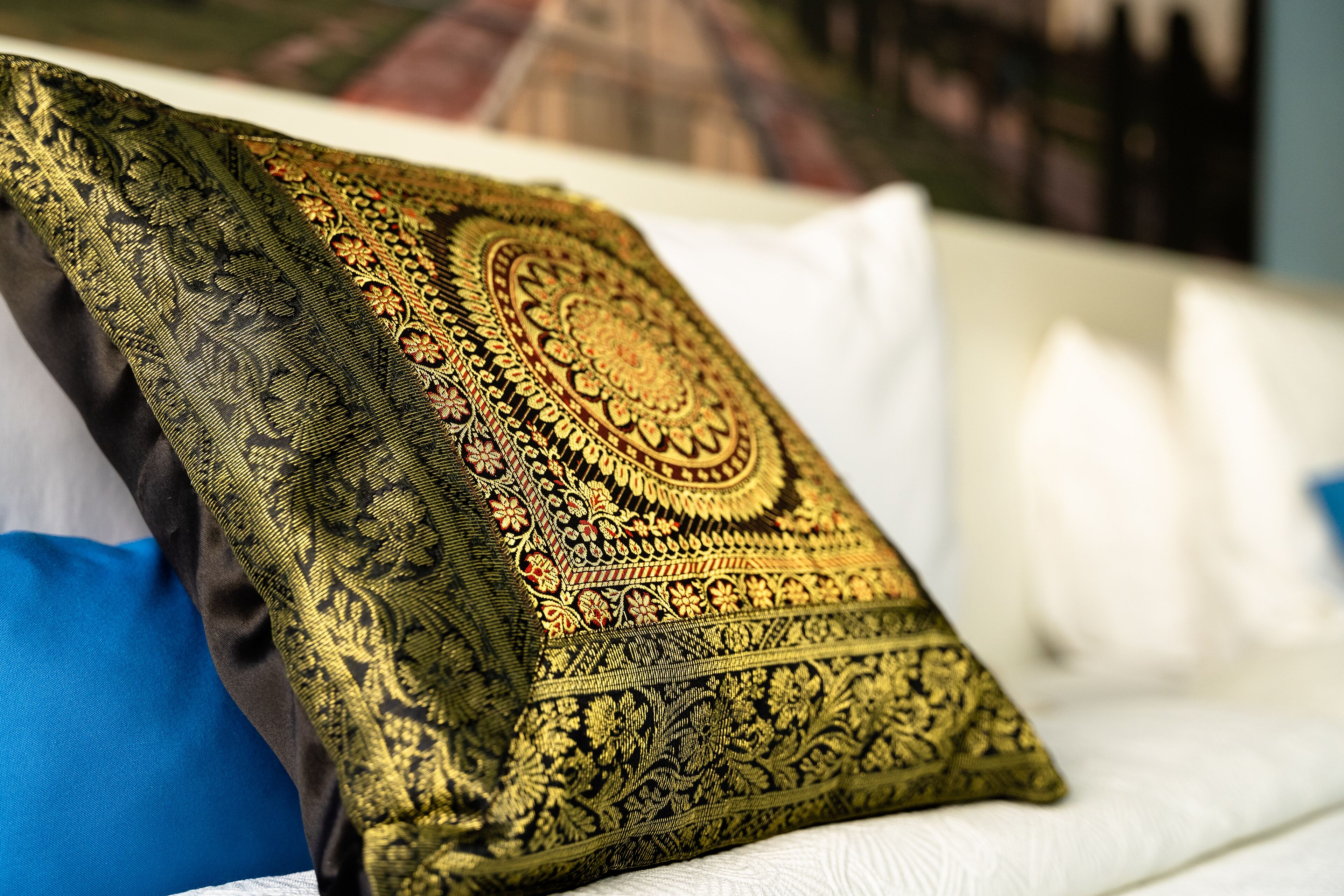 Una cama con una almohada estampada y una almohada azul.