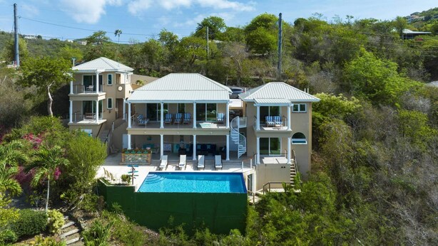 A multi-story house with a large swimming pool, balconies, and lush greenery surrounding the property. - Villa Colada, a 4-Bedroom St. John Villa Above Rendezvous Bay (St. John)