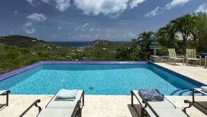 A clear blue pool with lounge chairs and a view of the ocean. - Villa Colada, a 4-Bedroom St. John Villa Above Rendezvous Bay (St. John)