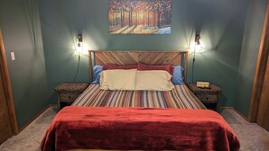 Een slaapkamer met een bed, twee nachtkastjes, een thermostaat en een schilderij aan de muur.