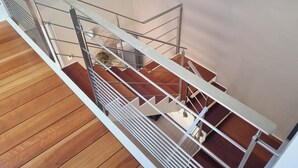 Eine moderne Treppe mit Metallgeländern und Holzhäuschen.