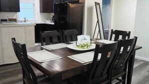 A dining area with a wooden table set for four, surrounded by black chairs. There is a small white sign on the table. - Country View Lodging In the heart of Amish Country (Baltic)