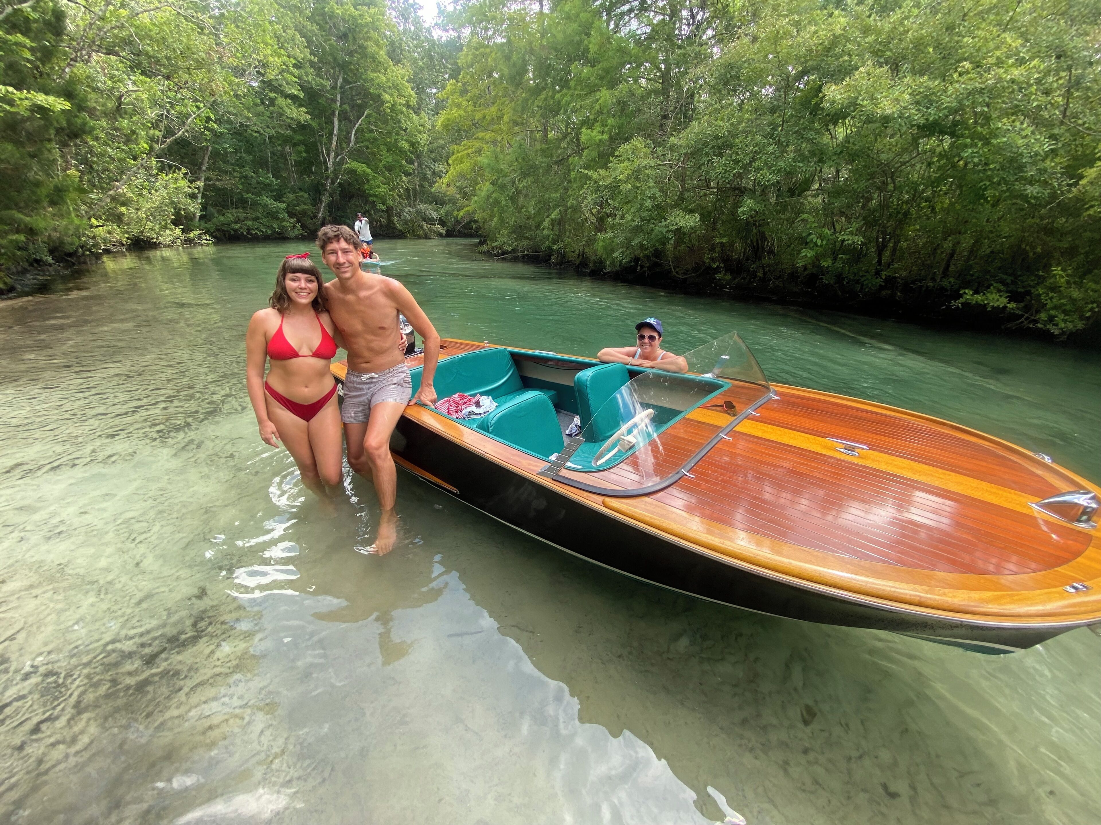 A wooden boat with a glass canopy, partially submerged in clear water.