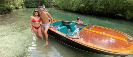 A wooden boat with a glass canopy, partially submerged in clear water.