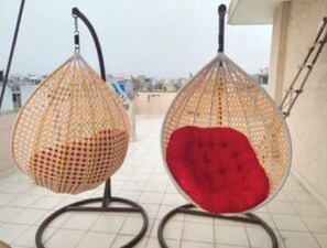 Hanging chairs suspended from a metal frame, perfect for outdoor relaxation.