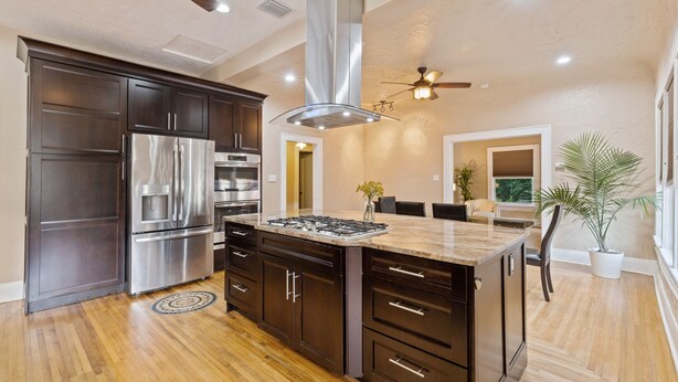 A modern kitchen with dark cabinetry, stainless steel appliances, and a central island. - 2x Properties + Pool + Pet Friendly (Lakeland)