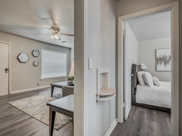 Relax in this serene bedroom with a large bed, bedside table, and ceiling fan.