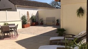 A patio with a table and chairs, a bench, and several potted plants. - Le Clos de Lescargot (DEMIGNY)