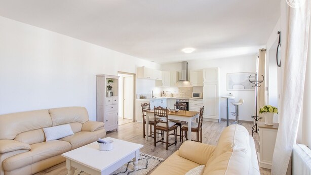 A modern living room with a sofa, coffee table, and dining area. - Le Clos de Lescargot (DEMIGNY)