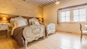 A bedroom with a rustic stone wall, a wooden ceiling, and a large window. - Une Pause à Outry - Ozenay (OZENAY)