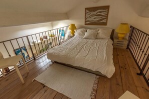 Relax in this serene bedroom with a large bed, two nightstands, and a balcony with a view.