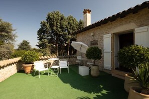 Relax in a tranquil setting with a patio featuring a comfortable seating area and lush greenery.