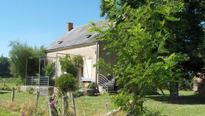 A rustic house with a sloped roof, a small porch, and a fenced yard. - Le Champ Bonnot - Rigny-sur-arroux (RIGNY-SUR-ARROUX)