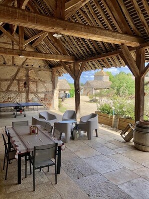 Relax in this serene outdoor space with a long dining table and comfortable seating.