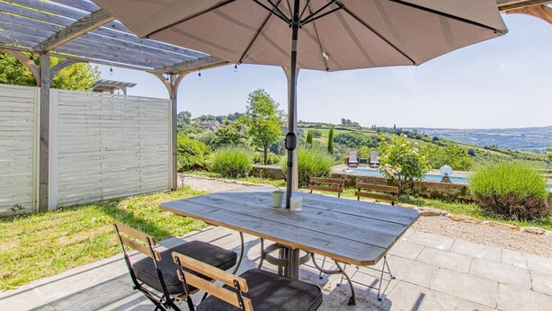 A patio with a wooden table and chairs, an umbrella, and a view of the countryside. - Le Puits - Saint Sernin DU Plain (SAINT SERNIN DU PLAIN)