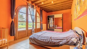 Un dormitorio con una cama grande, techo de madera y vistas al exterior a través de una ventana.