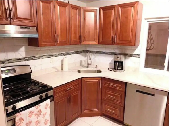 Kitchen features a stainless steel stove, sink, and dishwasher.