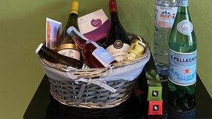A framed artwork of Cluny with a basket of wine bottles and a water bottle on a table. - le Petit Midi - Cluny (CLUNY)