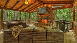 A wooden deck with a stone fireplace, outdoor seating, a hot tub, and a grill. - Broken Arrow - Hot Tub | Outdoor Fireplace | Screened In Porch (Blue Ridge)