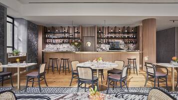 Un ristorante moderno con zona bar, elementi in legno e pavimento in marmo.