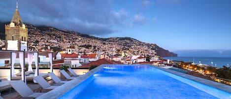 Una piscina al aire libre, sombrillas, tumbonas