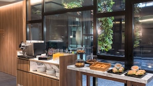 A modern breakfast bar with a coffee machine, juice, and various pastries. - Barcelo Funchal Oldtown (Funchal)