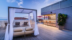 A rooftop bar with a bar counter and seating area, including a canopy and lounge chairs. - Barcelo Funchal Oldtown (Funchal)