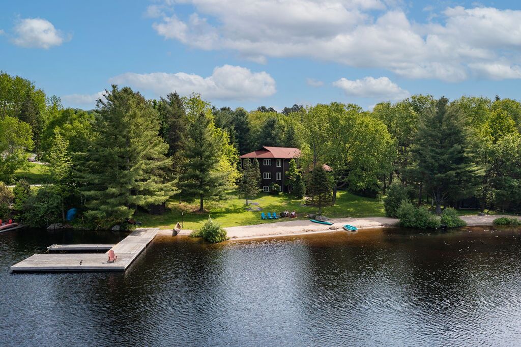 A lakeside property with a dock, a house, and surrounding greenery.