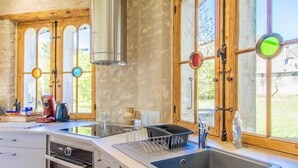 Una cocina con una isla grande, horno empotrado y campana extractora de acero inoxidable.