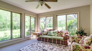 A sunlit room with a large window, a ceiling fan, and a plaid sofa. - Calm Country Oasis - Creek, ATV Trls & Norris Lake (Speedwell)