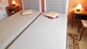 Un lit double avec une tête de lit matelassée, une table de chevet avec une lampe et une chaise.