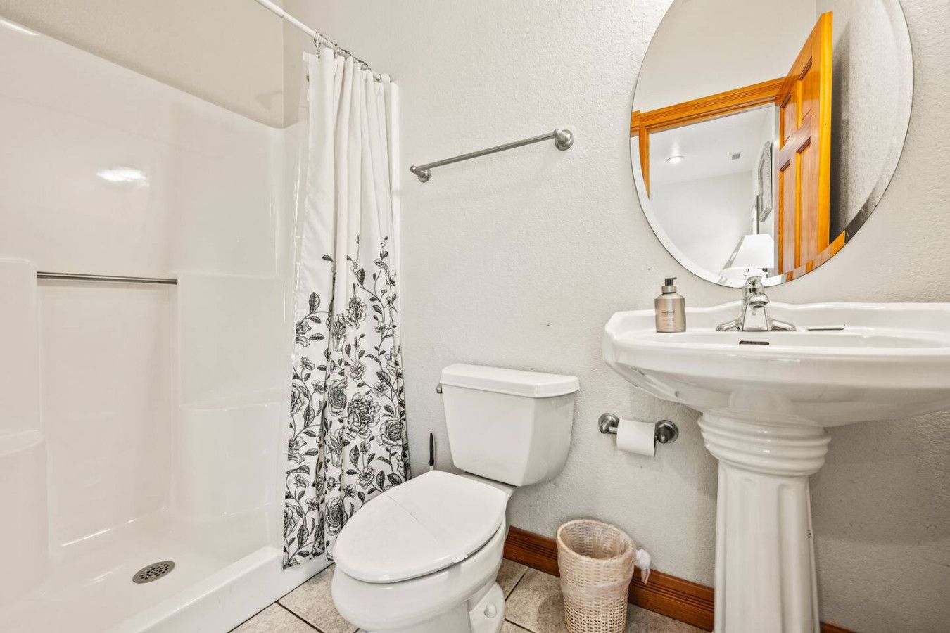 Ein Badezimmer mit Dusche, Toilette, Waschbecken und Spiegel.