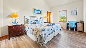 Un dormitorio con cama, escritorio, silla, ventilador de techo y ventana con persianas.