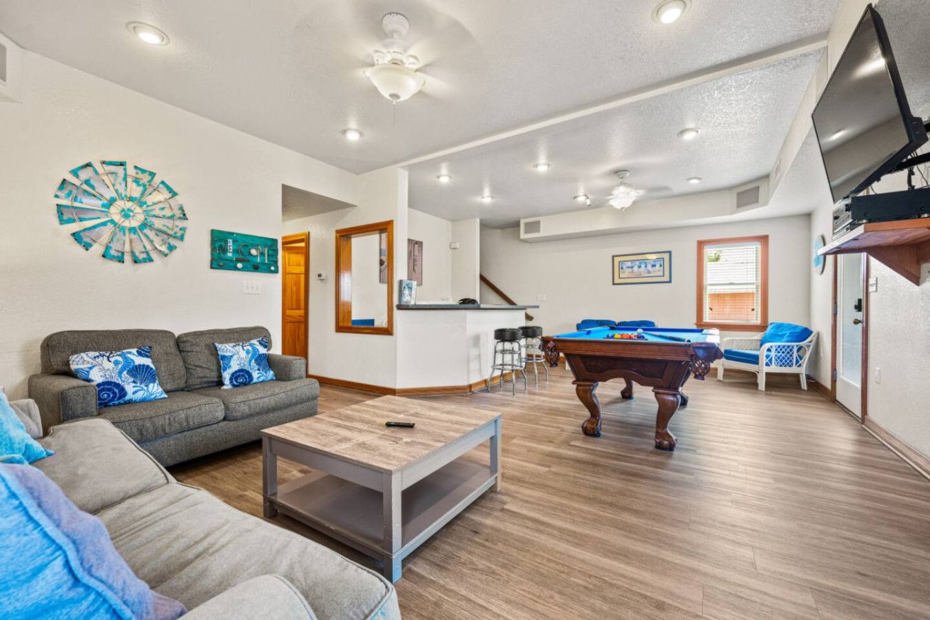 Sala de estar com mesa de bilhar, sofá e mesa de centro.