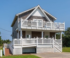 A two-story house with a balcony, a covered porch, and a front entrance. - Cozy  Beach House 4BR, Hot tub, Pets OK (Rodanthe)