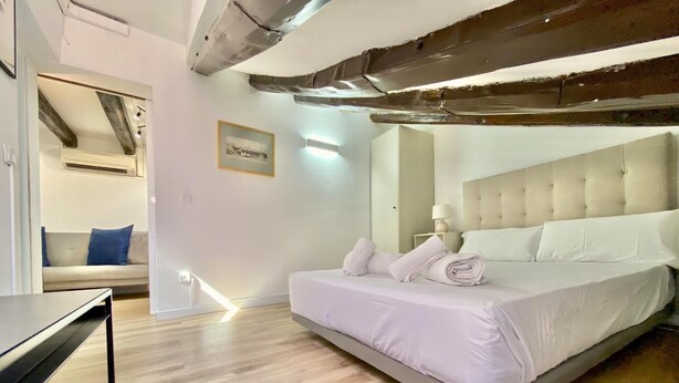 Une chambre moderne avec un grand lit, un canapé et un bureau.