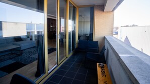 A modern apartment with a balcony, large sliding glass doors, a sofa, and a dining table. - Zaanse Schans Apartments (Wormer)