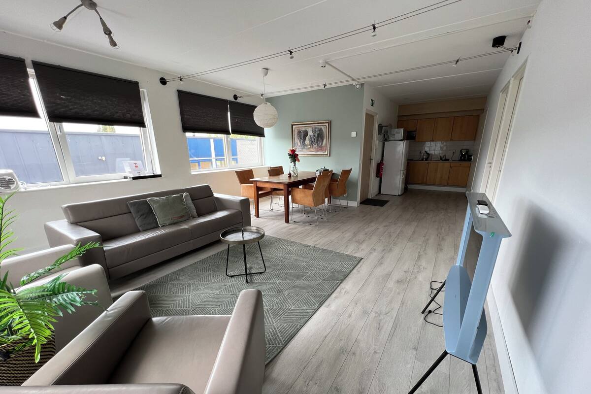 Un salon moderne comprenant un canapé, une table à manger et un coin cuisine.