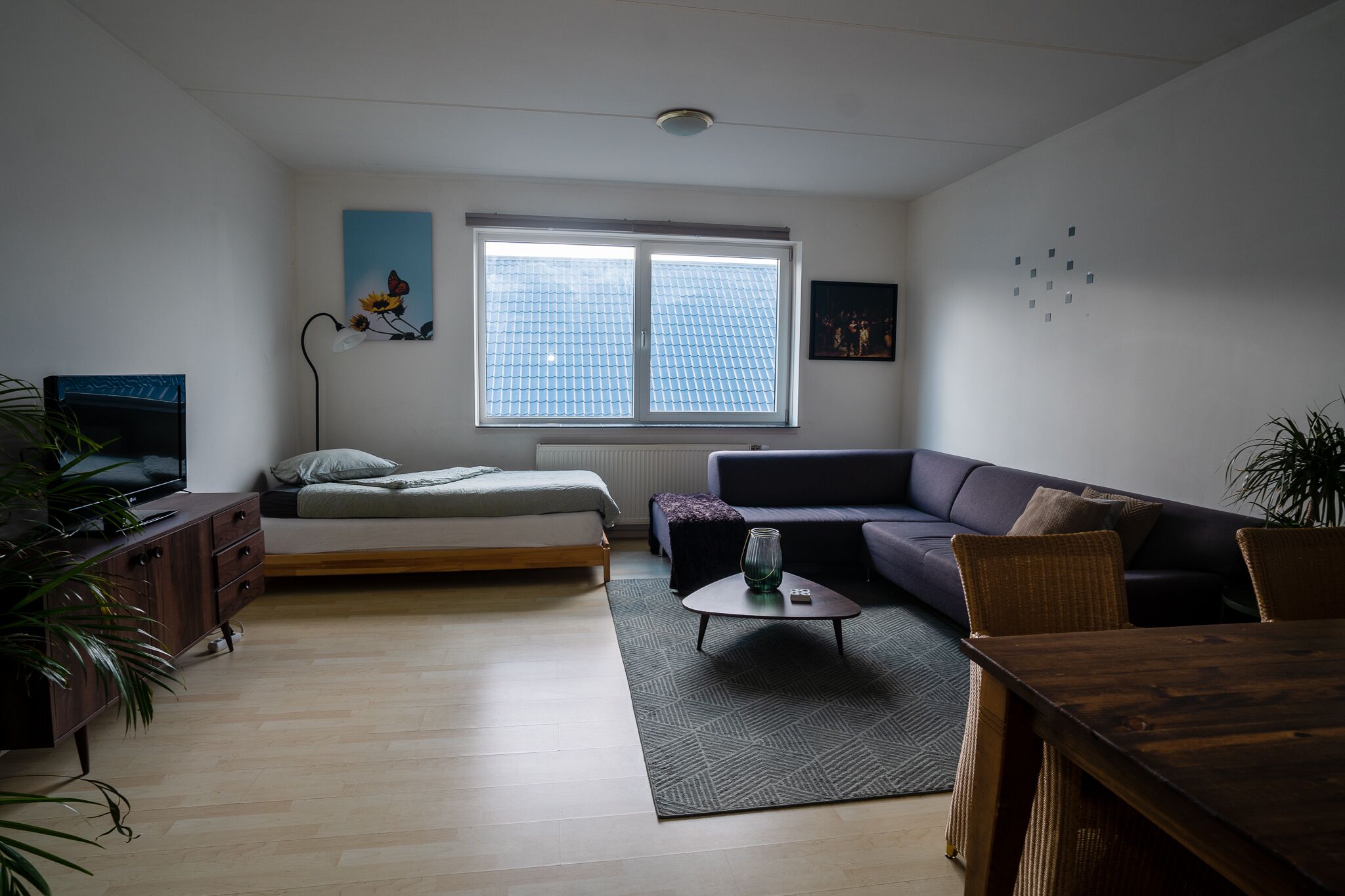 Ett modernt vardagsrum med en säng, en soffa och ett matbord.