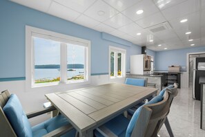 A modern kitchen with a dining area, large windows with a view, and a clean, contemporary design. - Seal’s Haul. Water's edge living in this 1 BR and 1 BA first floor unit. (Harpswell)