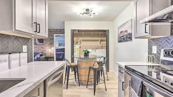 A modern kitchen with a central island, bar stools, and a built-in oven.