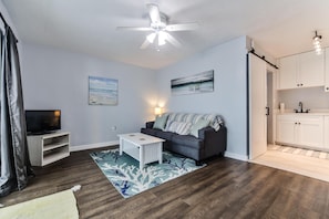 Relax in this stylish living room with a sofa, coffee table, and mounted TV.