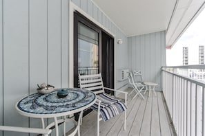 Enjoy the city view from this balcony with a small table and two chairs.