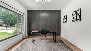 A modern room with a large window, a table, and abstract art on the wall. - Top Notch 2 (Atlanta)